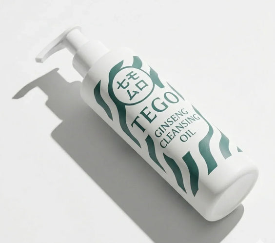 Flaska med pump, märkt 'Ginseng Cleansing Oil', vit bakgrund, hudvårdsprodukt