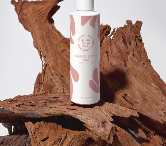 Barrier Boost tonerflaska för hudvård på träbit, minimalistisk design, K-beauty produktfoto.